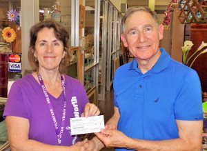 David Moss, chairman of the Mission Endowment Fund of PEACE Lutheran Church, presents a check for $500 from MEF to Women of Worth.