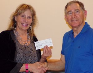 David Moss, financial secretary for PEACE Lutheran Church's Mission Endowment Fund, presents a donation from MEF to Donna Raibley, founder of One Source Empowering Caregivers.