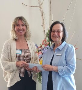 Chris Schwarz, co-chairman of the Mission Endowment Fund of PEACE Lutheran Church, presents a check for $500 from MEF to Community Beyond Violence executive director, Allison Bischofberger.