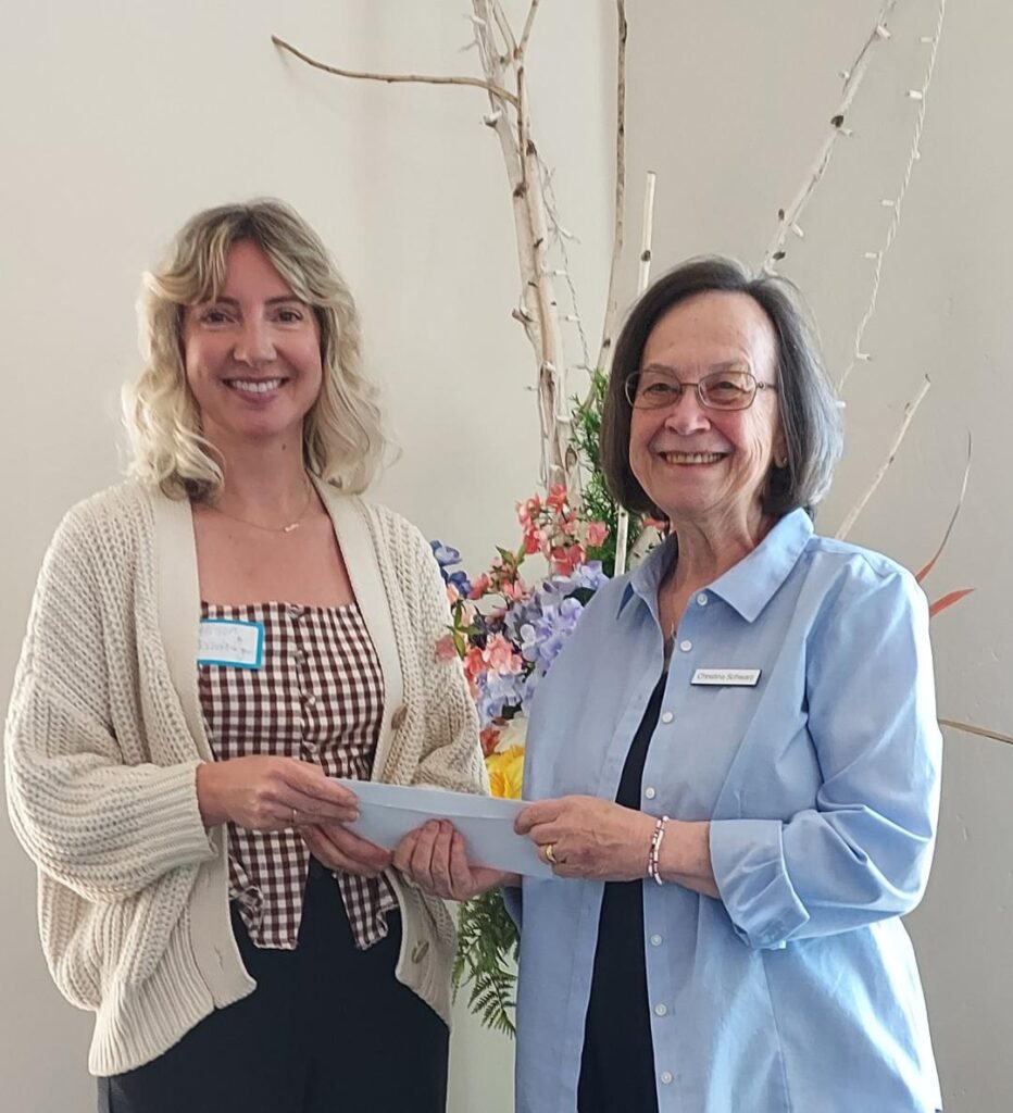 Chris Schwarz, co-chairman of the Mission Endowment Fund of PEACE Lutheran Church, presents a check for $500 from MEF to Community Beyond Violence executive director, Allison Bischofberger.